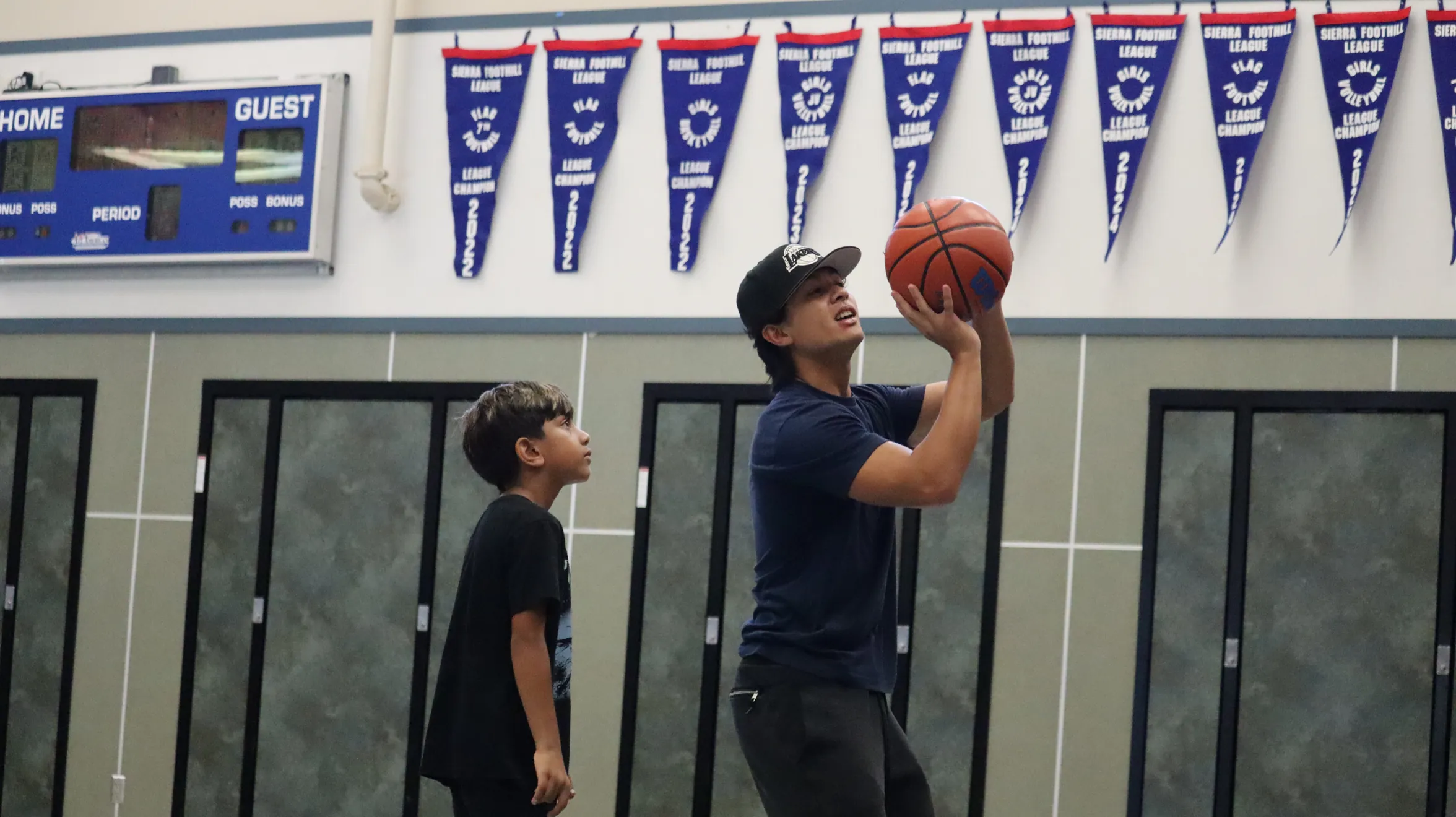 Coach helping a young athlete with basketball shooting form