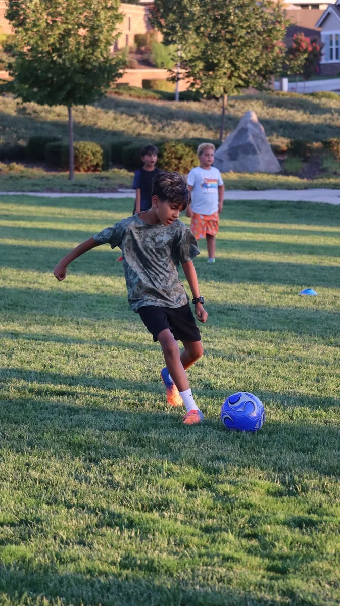 Young athlete kicking a soccer ball during a training drill
